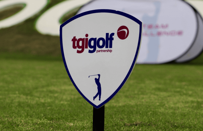 A TGI Golf Partnership branded shield sign on a golf course