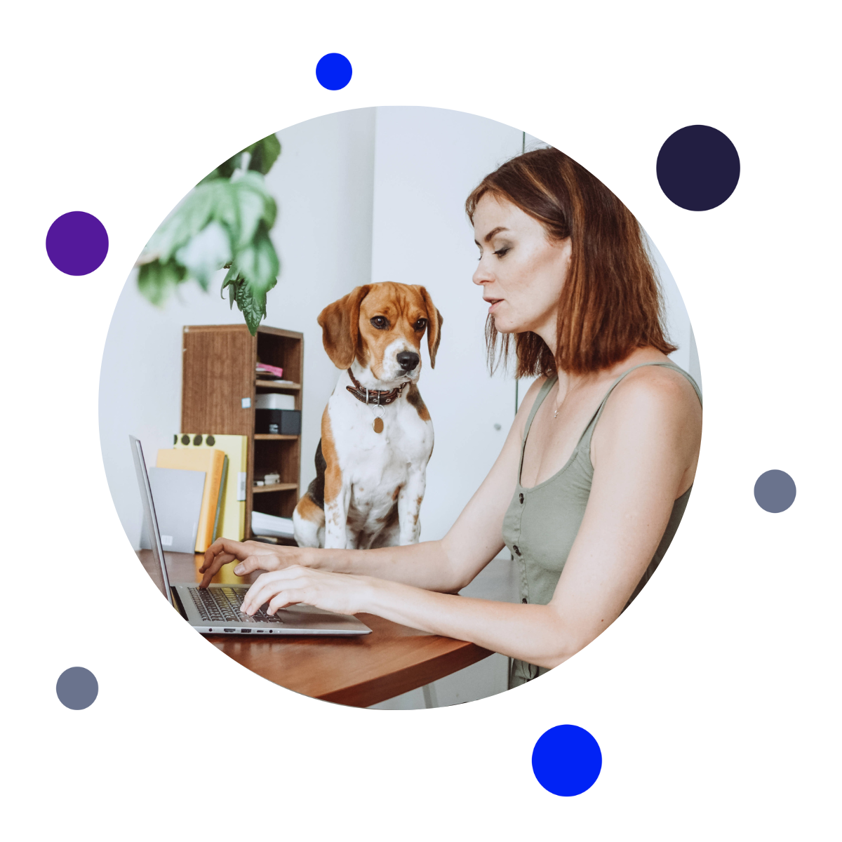 Woman working from home with her dog sat next to her laptop