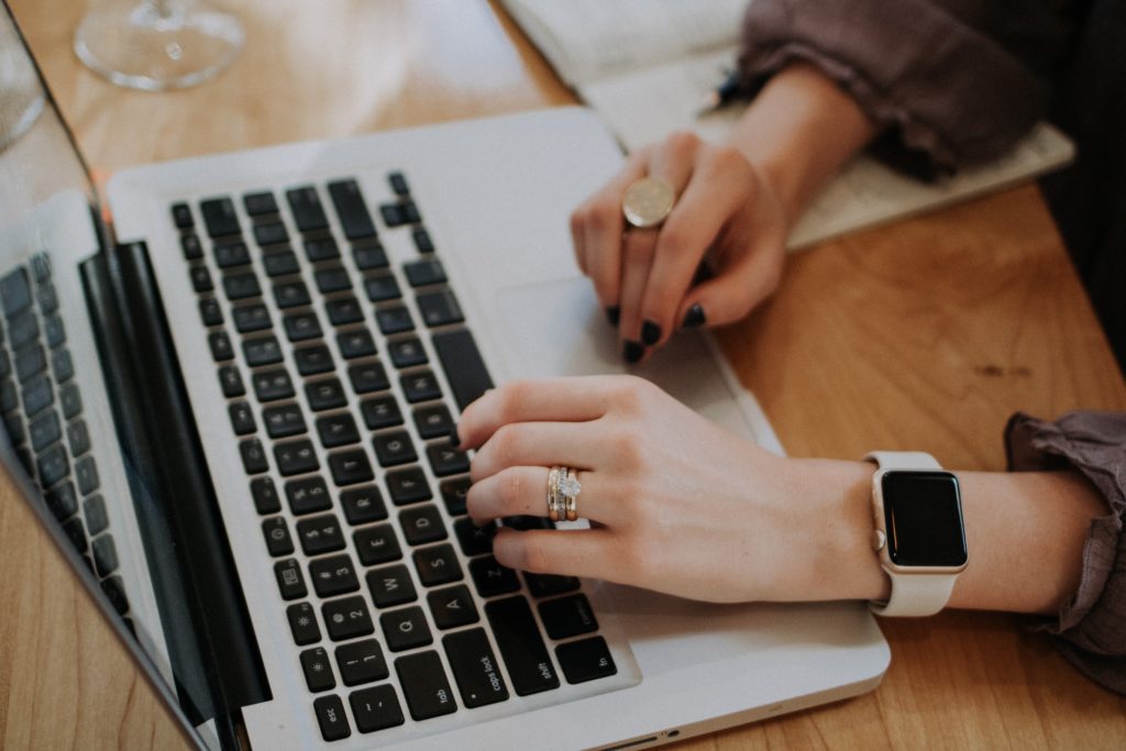 Women's hands typing on a laptop