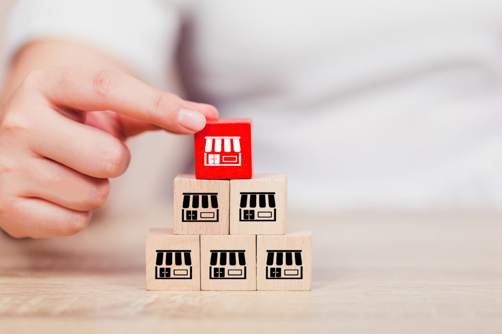 Wooden blocks with icons to represent businesses, stacked up