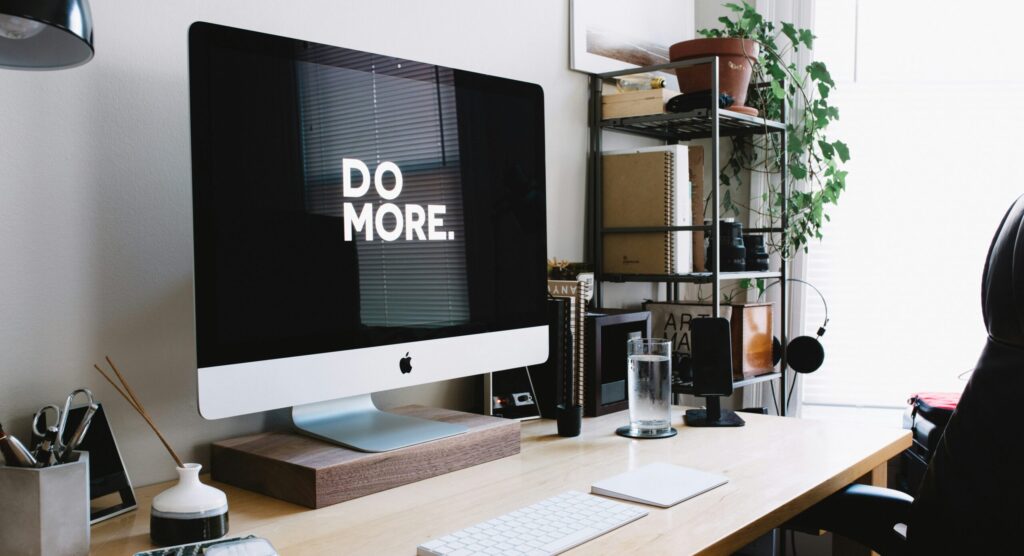 Desk with an Mac desktop with 'Do more' on the screen.